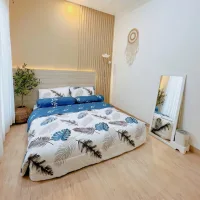 Small bedroom with a low-profile bed, wood accent wall, wall mirror, floor lamp, and minimal decor that maximizes the available space.