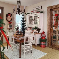 Cozy winter dining room with a rustic wooden table, white chairs, vintage cabinet, Christmas decorations, and warm seasonal accents.
