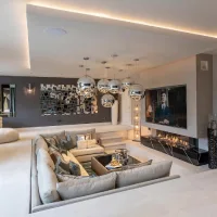 Luxurious sunken living room with a large sectional sofa, fireplace, TV wall, and modern pendant lights.