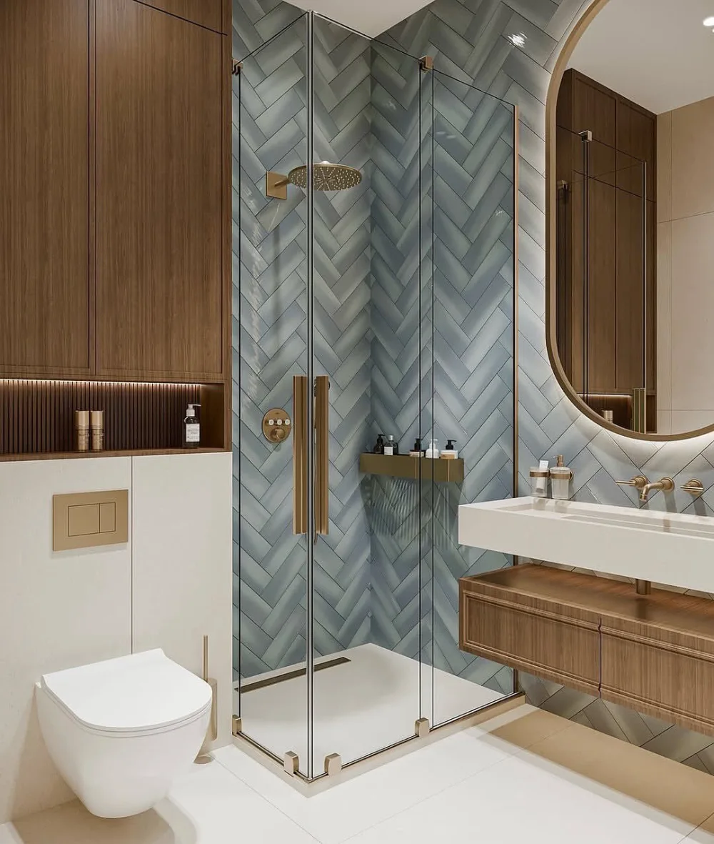 small modern bathroom with blue-gray herringbone shower tile, glass enclosure, floating wood vanity, and wall-mounted toilet