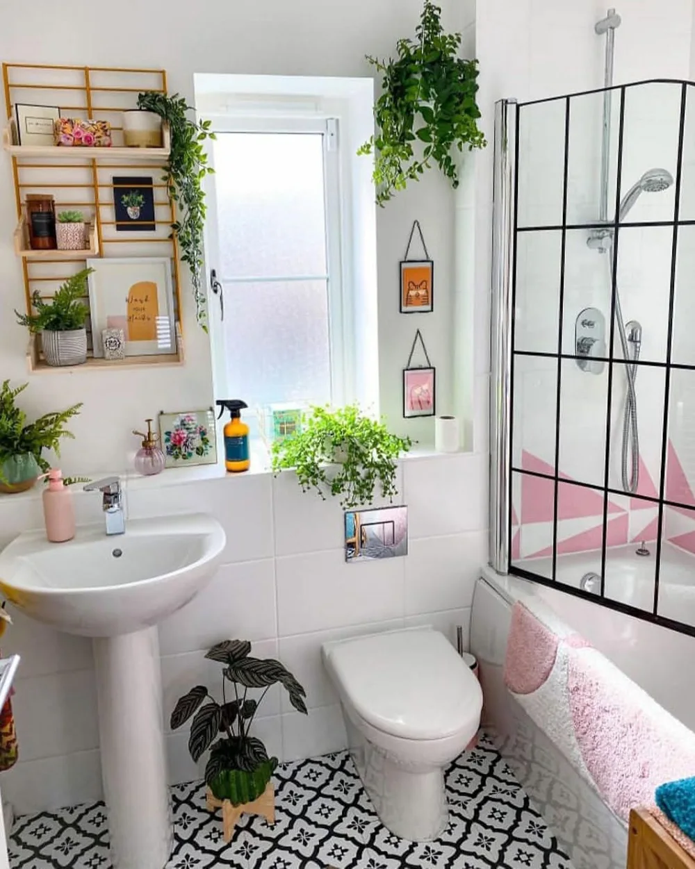 Bright white bathroom with trailing plants around the window and shelves