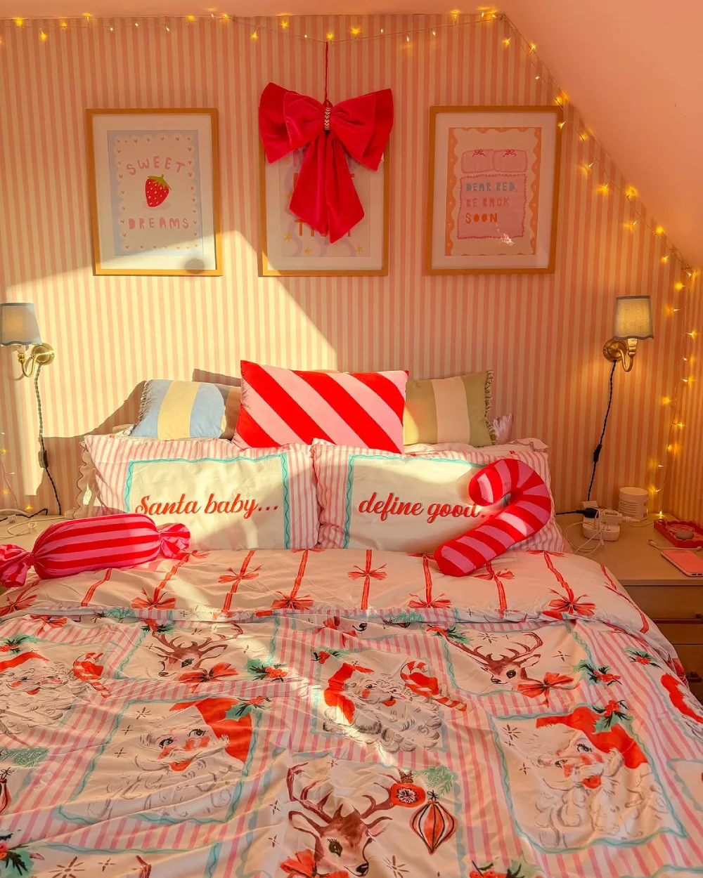 Playful Christmas bedroom with pink striped walls, candy cane pillows, and festive bedding