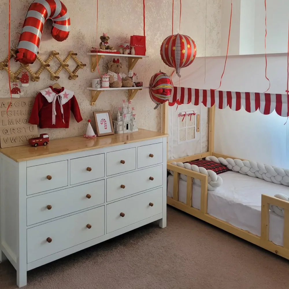 Cozy cabin bedroom with teepee beds, Christmas lights, and a decorated tree