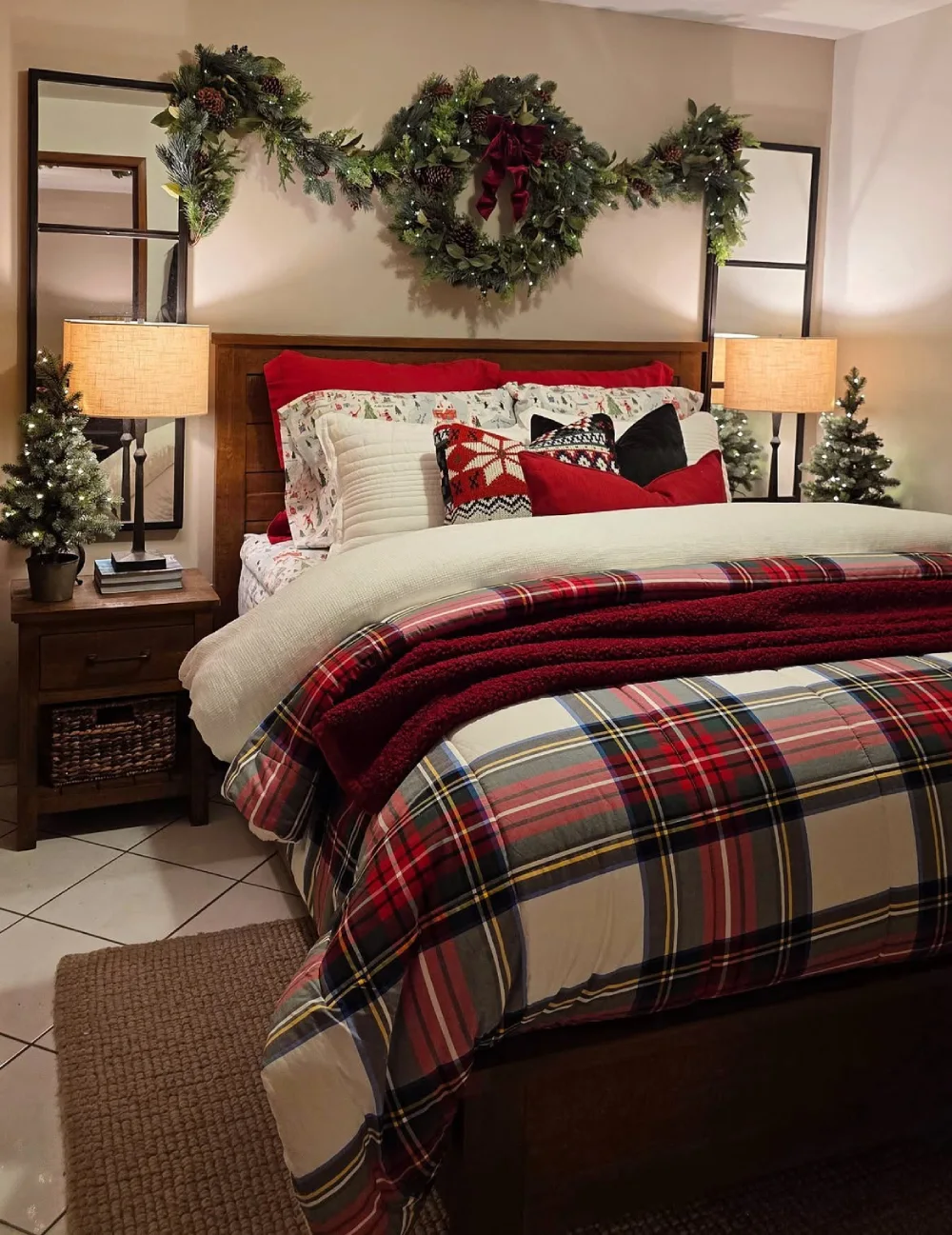 Cozy bedroom with layered red plaid bedding, knit blankets, and Christmas garland