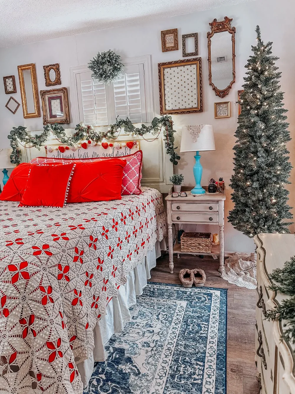 Vintage-inspired Christmas bedroom with red bedding, crochet blanket, and antique frames
