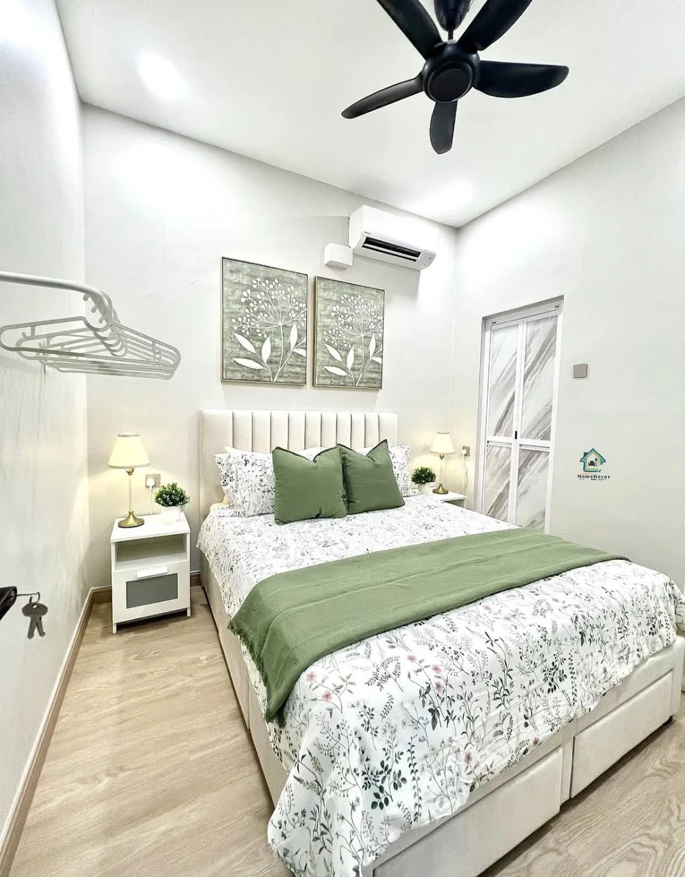 Small bedroom with a white upholstered bed, green bedding, narrow nightstands, and light wood floor