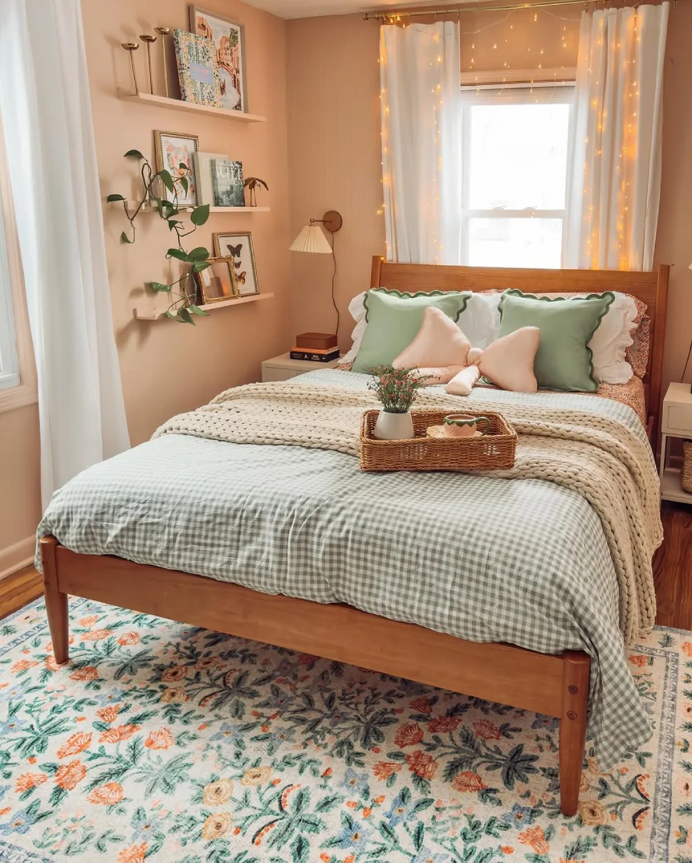 Small bedroom with a wooden bed, wall shelf, plants, and neutral green bedding