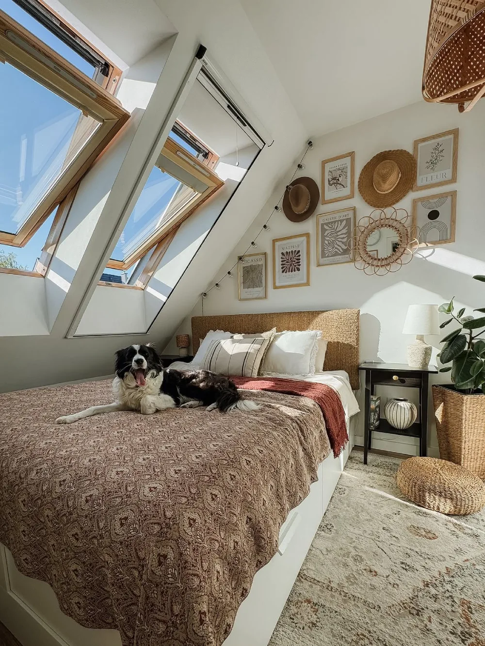 Attic bedroom with skylights, a low bed, and woven decor