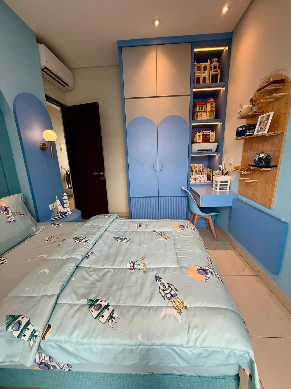 Blue small bedroom with a built-in wardrobe, desk, and open shelving