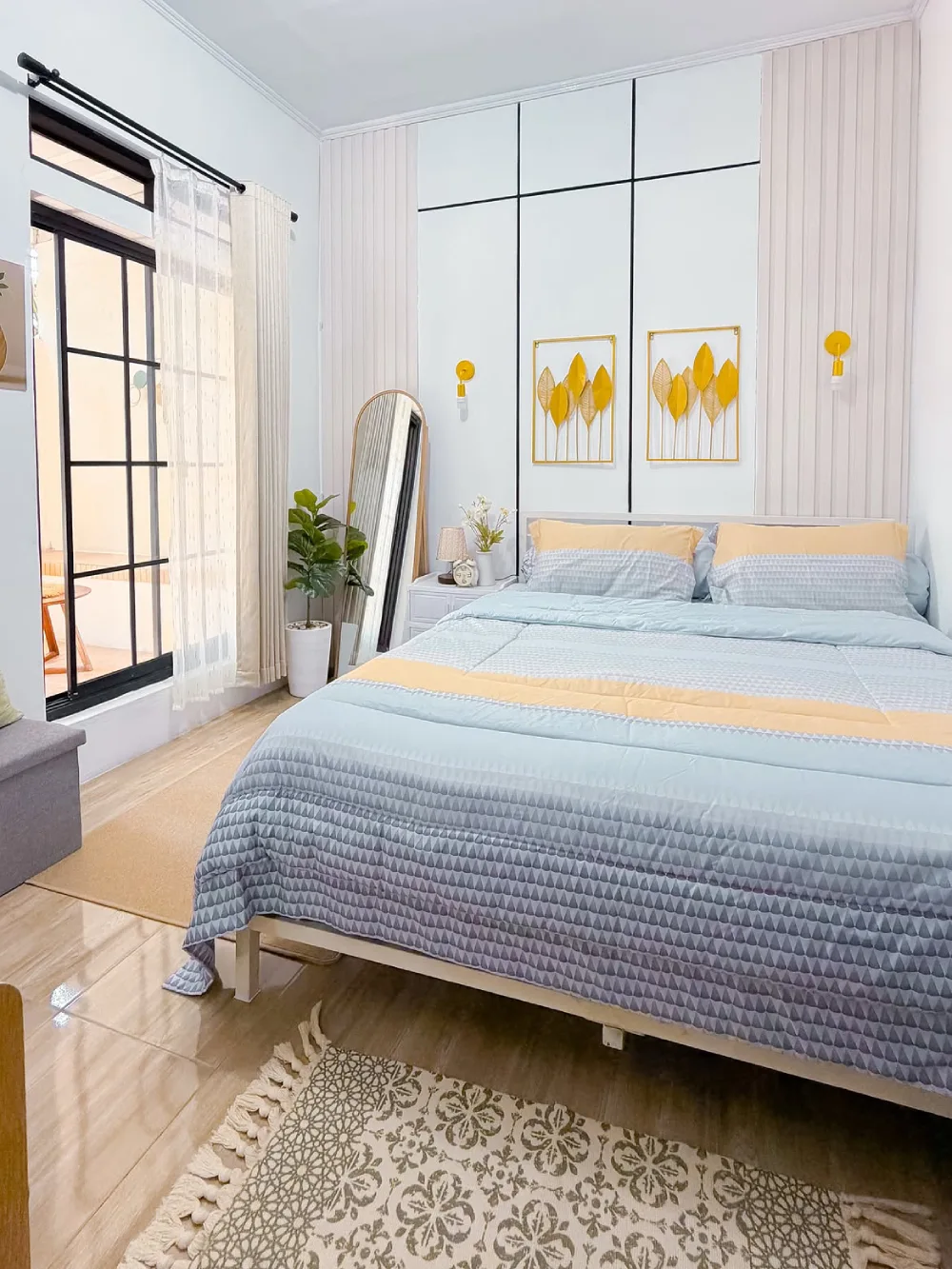 Small bedroom with a large bed, floor mirror, plant, and built-in wall storage