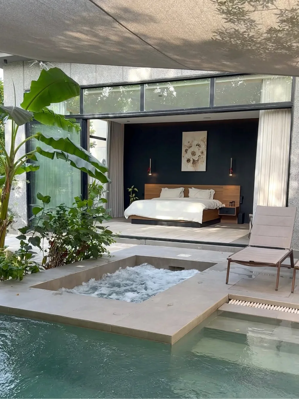 bedroom opening to a private pool with a garden courtyard