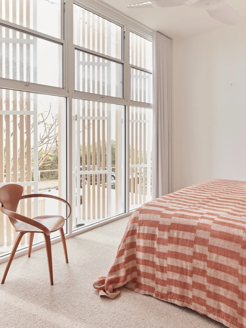 bedroom with floor-to-ceiling windows and vertical privacy screens outside