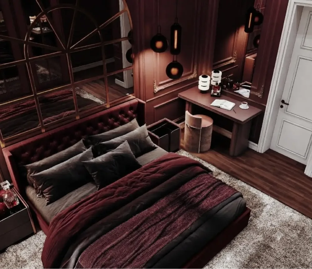 Moody burgundy bedroom with dark paneled walls, a tufted leather headboard, charcoal bedding, and warm pendant lighting