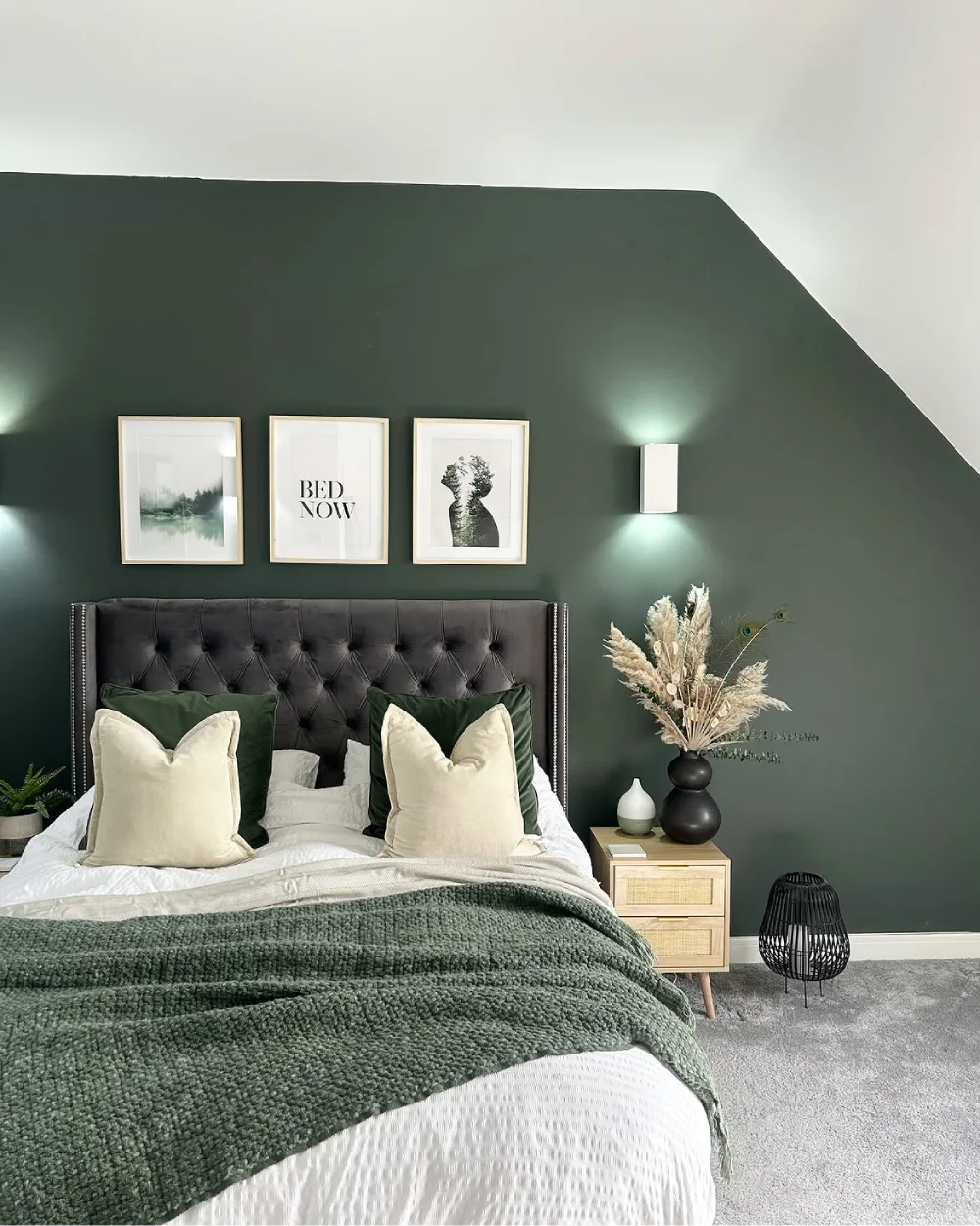 Bedroom with dark green walls, a charcoal tufted headboard, cream pillows, and textured green bedding