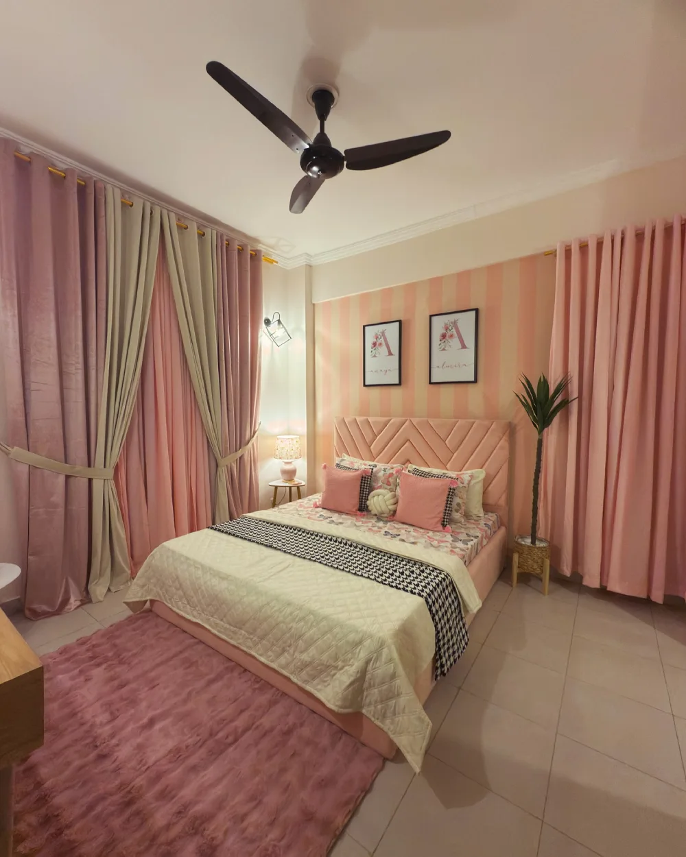 Pink bedroom with striped wallpaper, blush curtains, and a geometric upholstered headboard