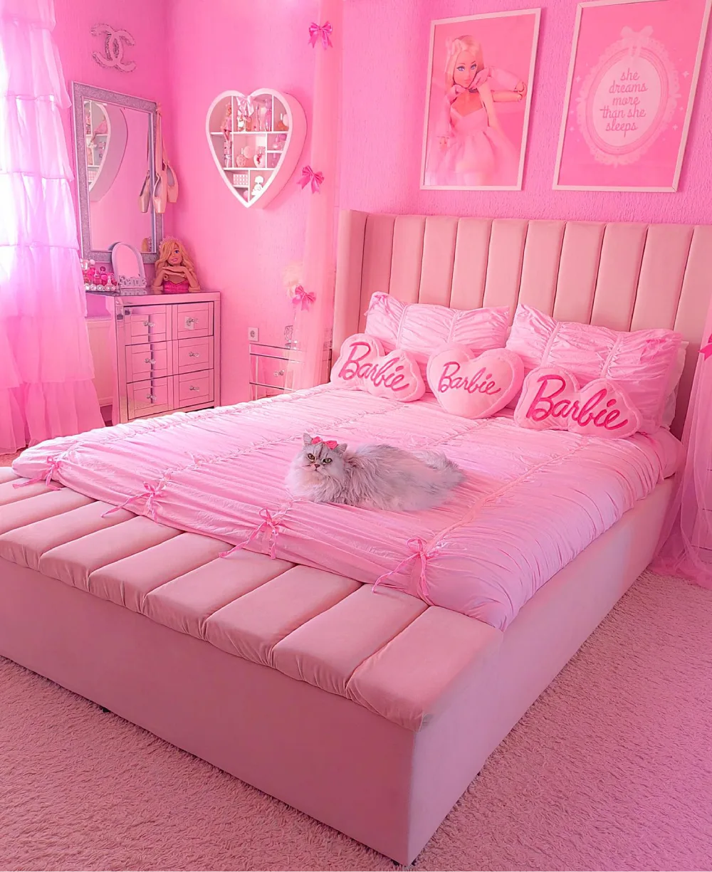Vibrant Barbie-inspired pink bedroom with a blush upholstered bed, Barbie heart pillows, pink walls, and a matching vanity