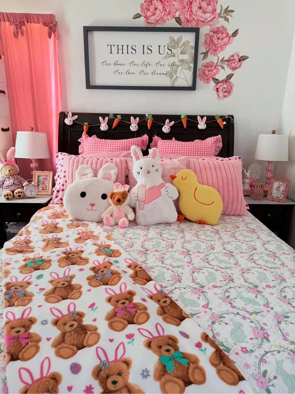 Pink bedroom decorated with bunny stuffed animals, floral bedding, gingham pillows, and matching pink curtains