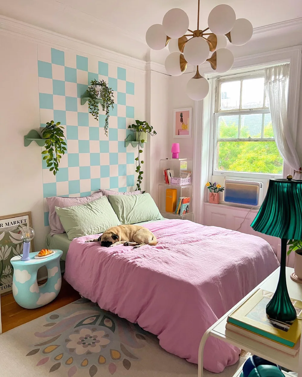 Pastel bedroom with a mint green and blush pink checkerboard accent wall, pink bedding, mint pillows, and playful modern lighting