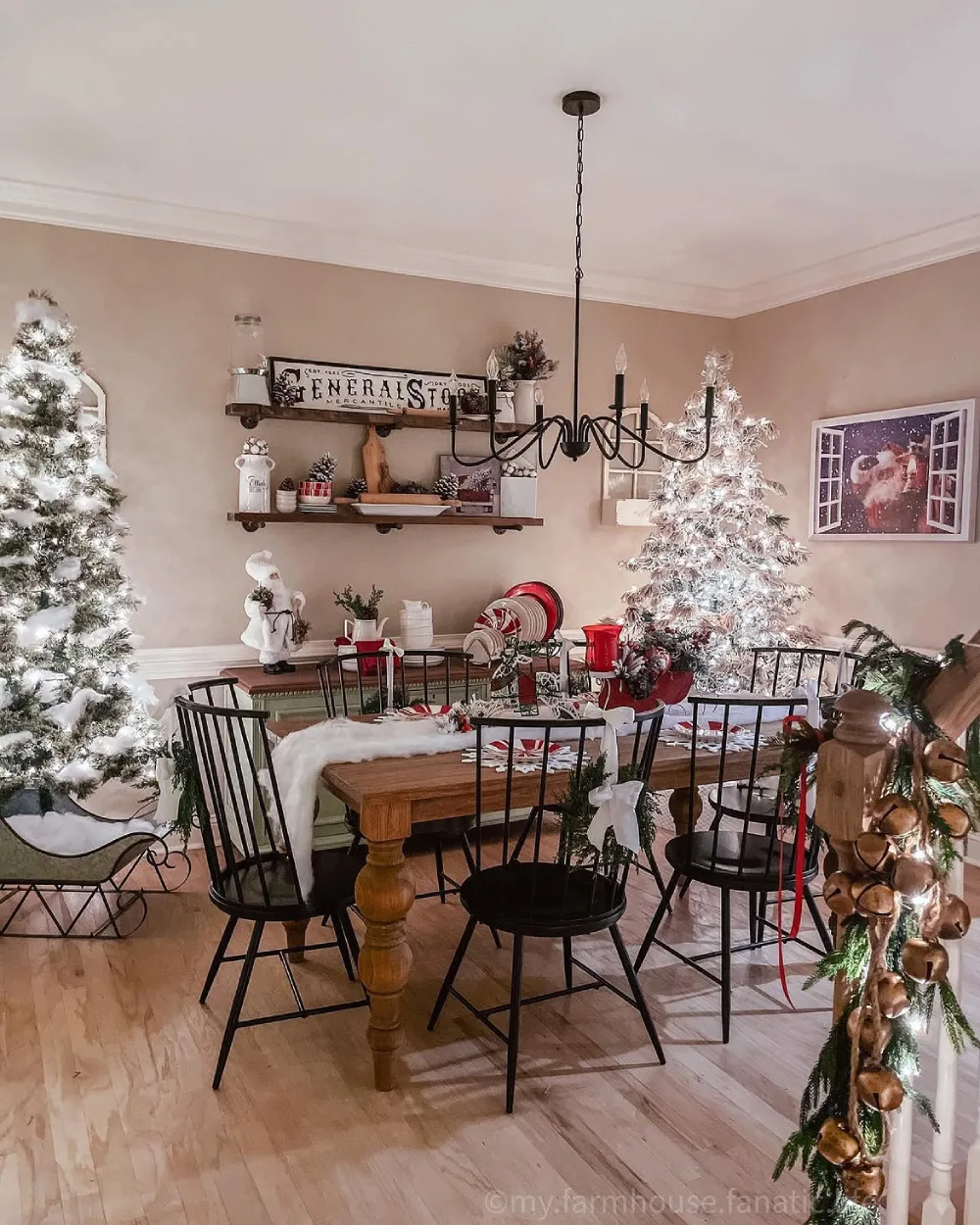Cozy farmhouse winter dining room with black spindle chairs, wooden table, and glowing Christmas trees