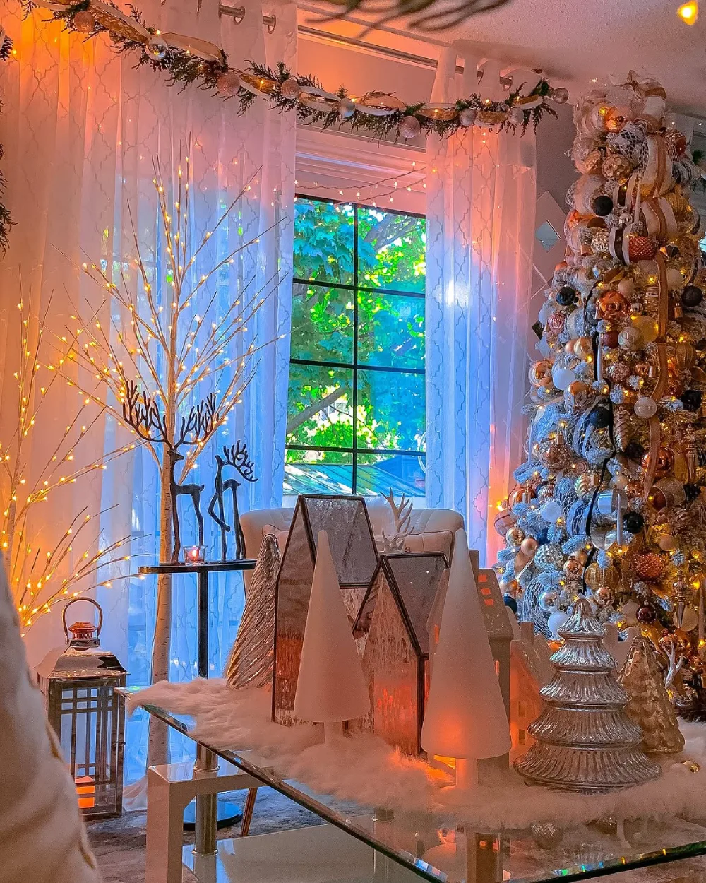 Winter dining area decorated with twinkle lights, greenery, and a heavily decorated Christmas tree