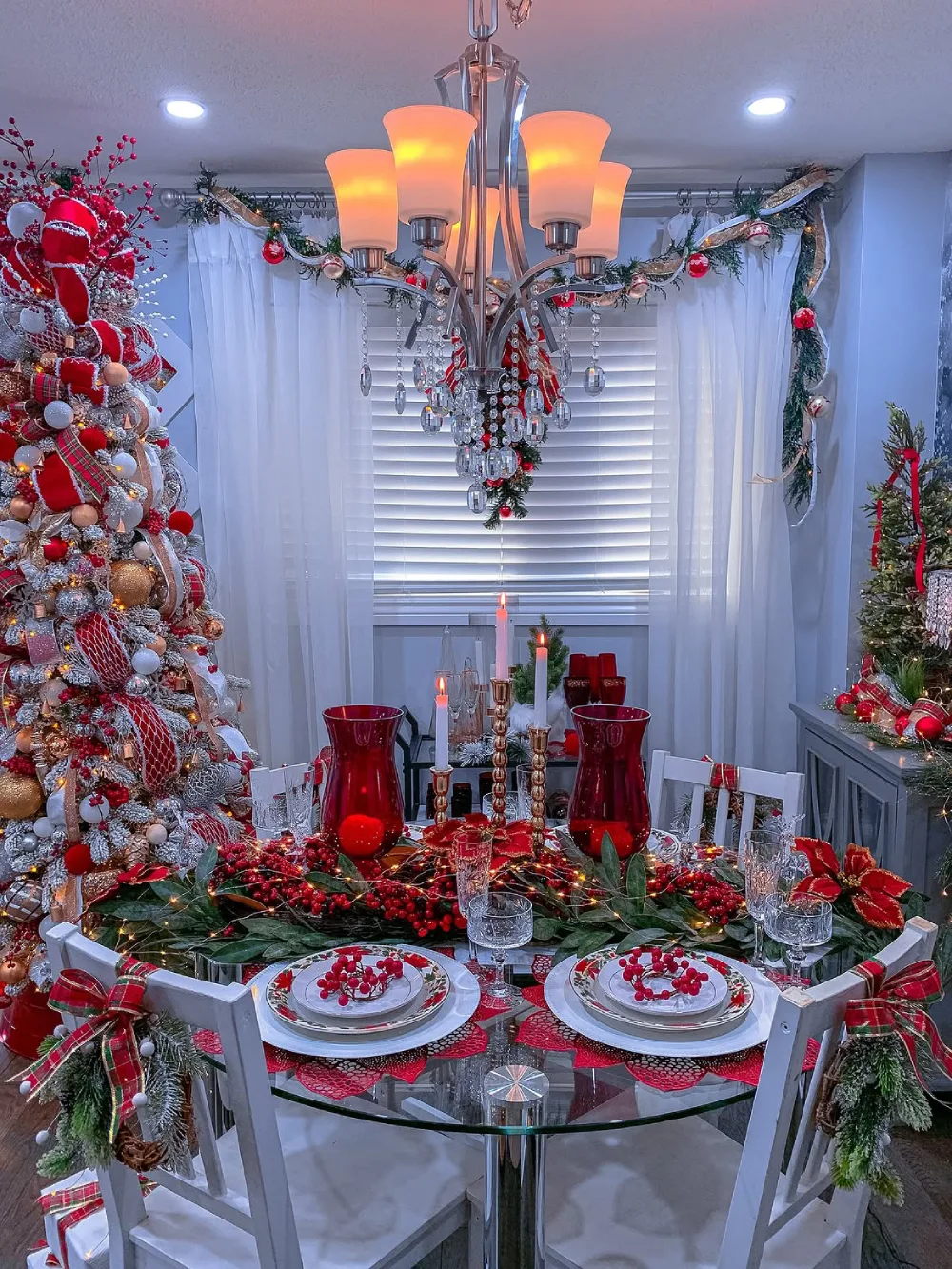 Festive winter dining room with red glassware, berries, candles, and Christmas decorations