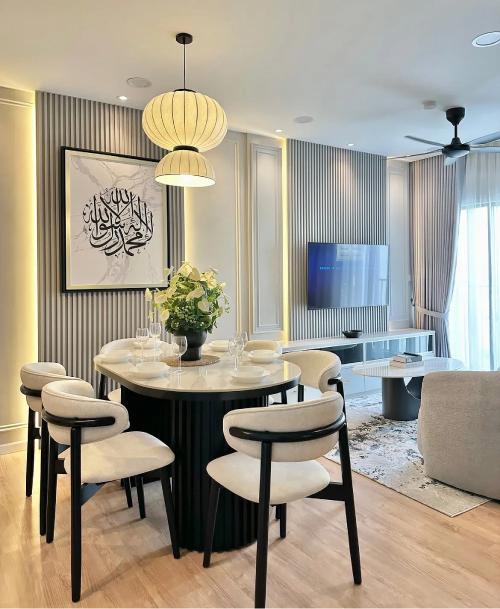 Modern dining area with a round table, cream upholstered chairs, and black vertical wall panels beside the living room