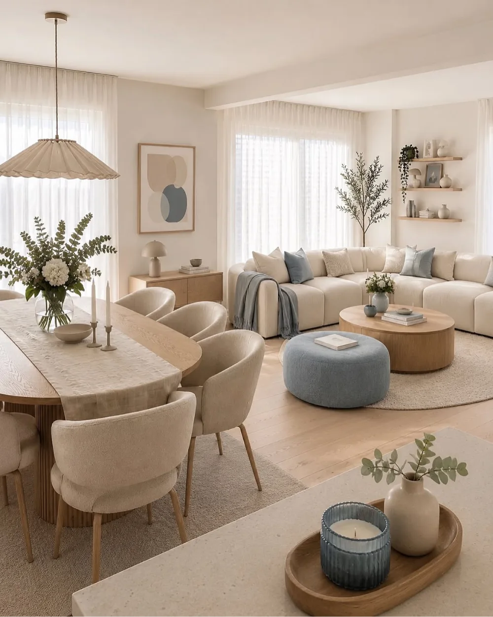 Soft neutral open-concept dining and living room with cream seating, a wood table, and blue accents