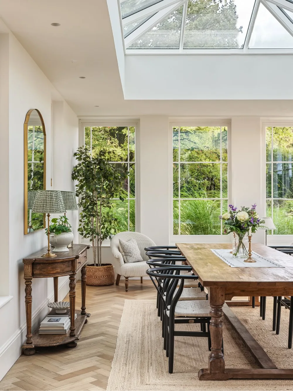 Open dining space with a warm wood table, black cross-back chairs, and built-in wooden cabinetry