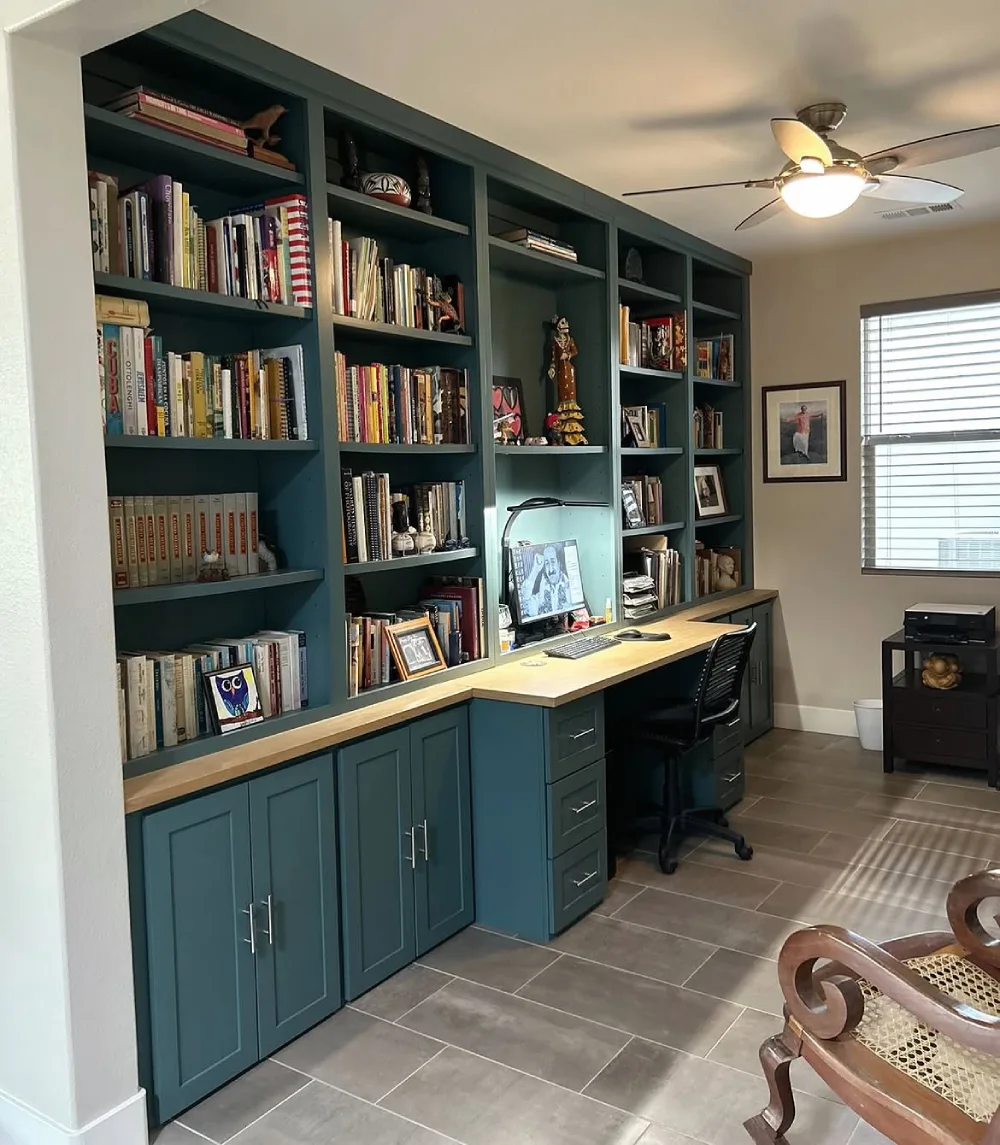 blue built-in bookshelf with two desks and white office chairs