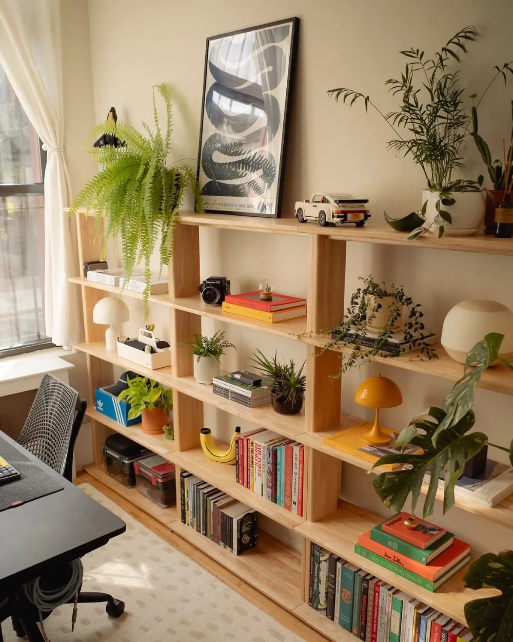 warm wood bookshelf decorated with books, plants, and home office accessories