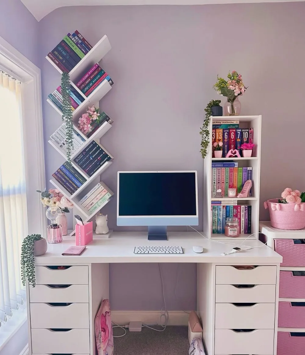 pink home office with a decorative bookshelf beside a white desk