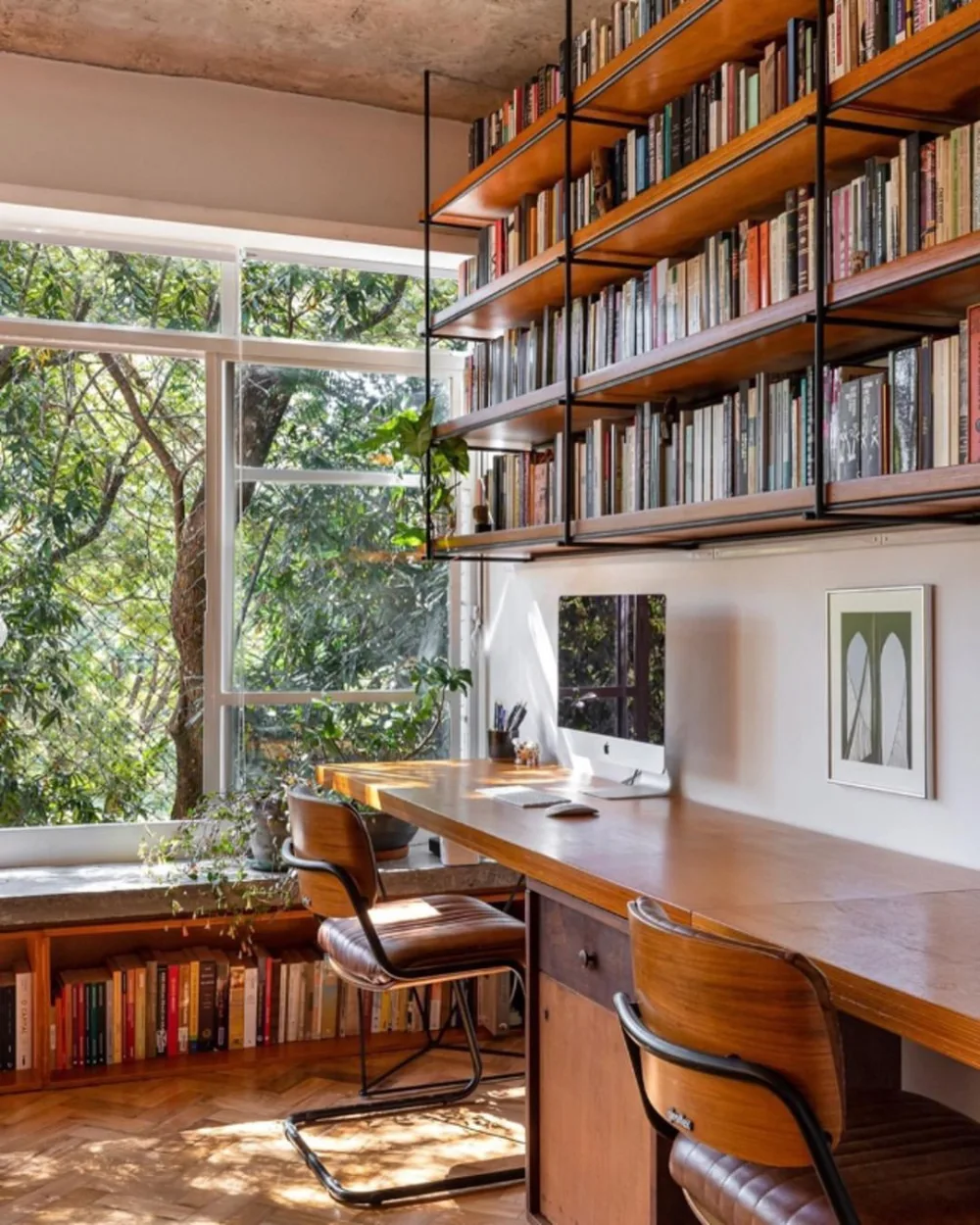 wood and black metal floating bookshelf above a home office desk
