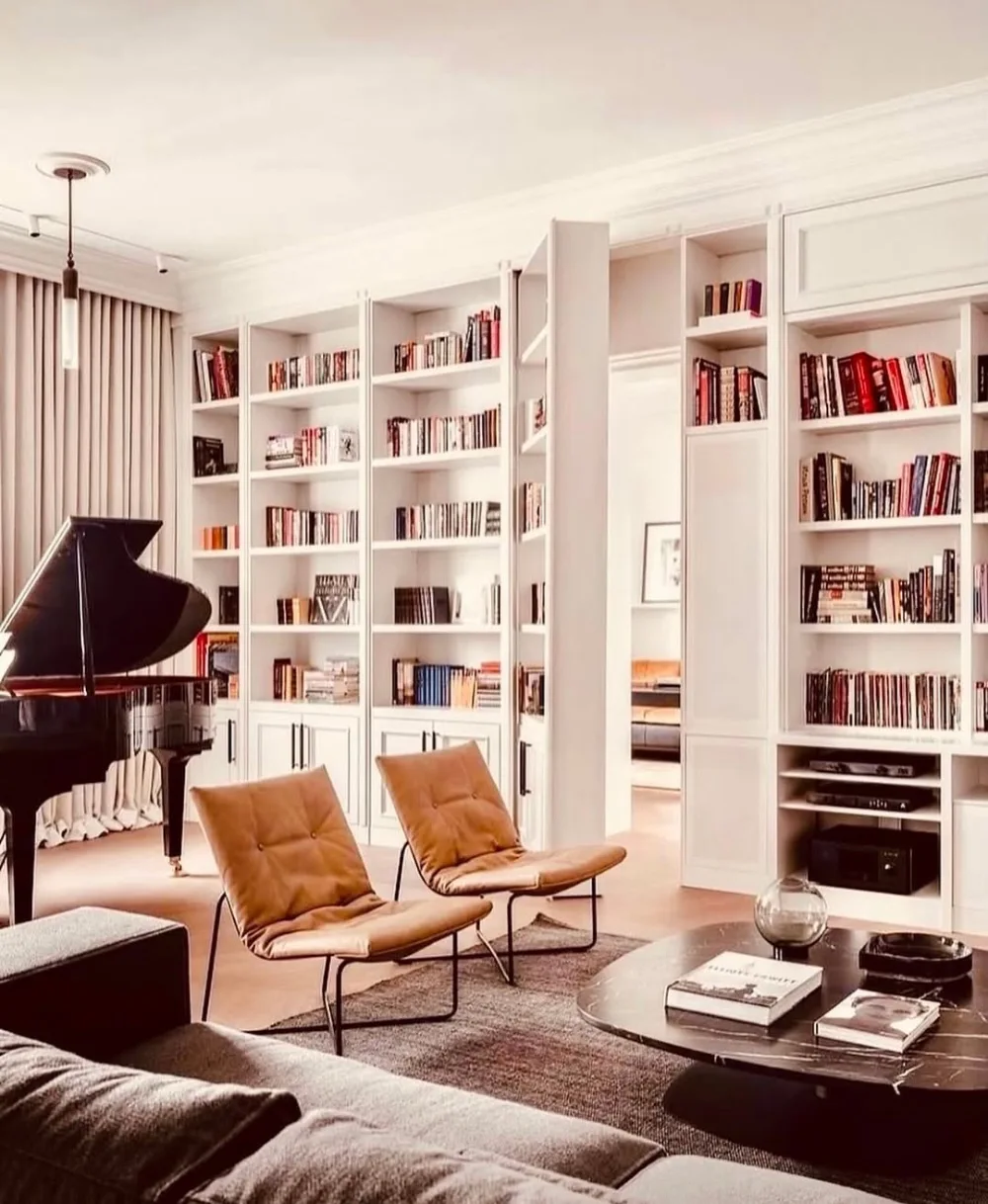white built-in library wall filled with books in a bright home office