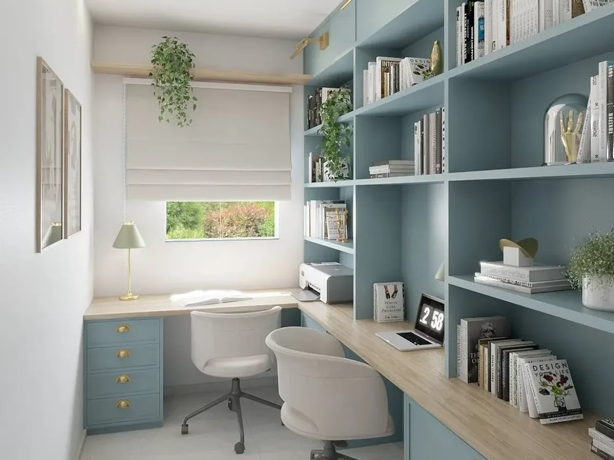 Blue built-in bookshelf with a wood desk, books, plants, and two white office chairs in a bright home office.