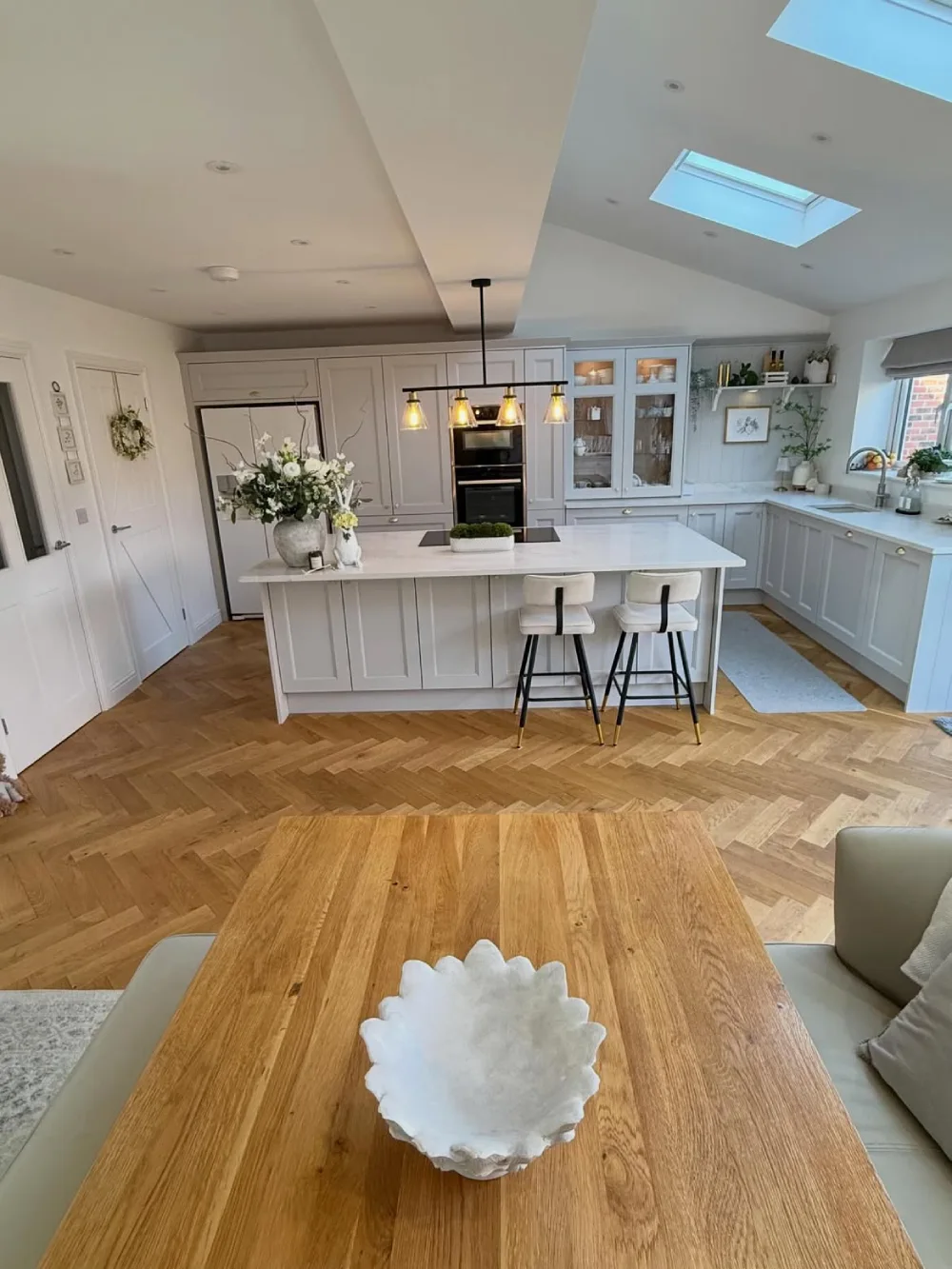 open-concept kitchen with light gray cabinets, island, and adjoining dining table