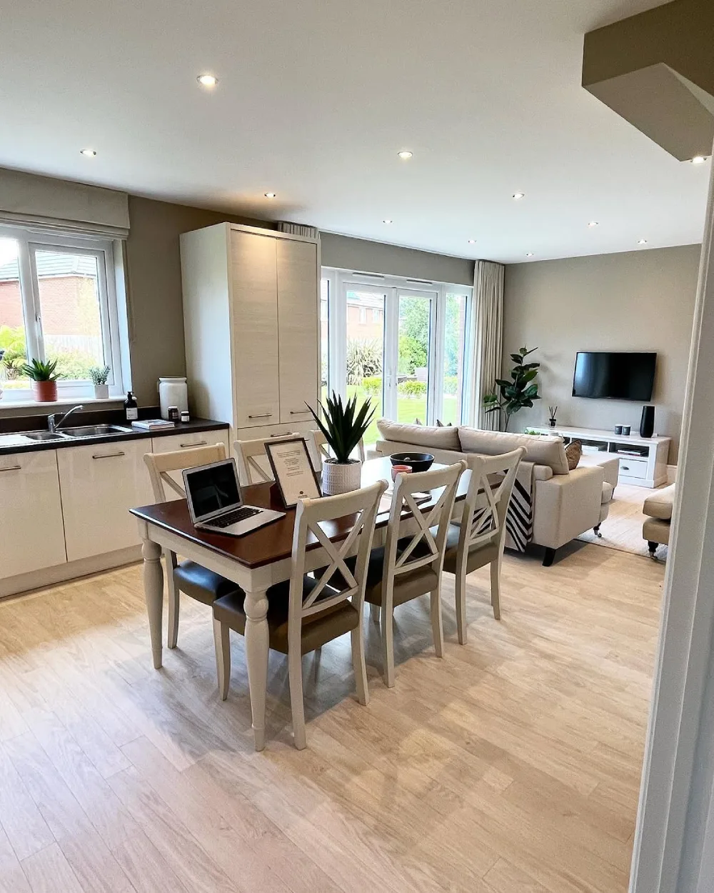 open-concept kitchen with light cabinets, dining table, and adjoining living room