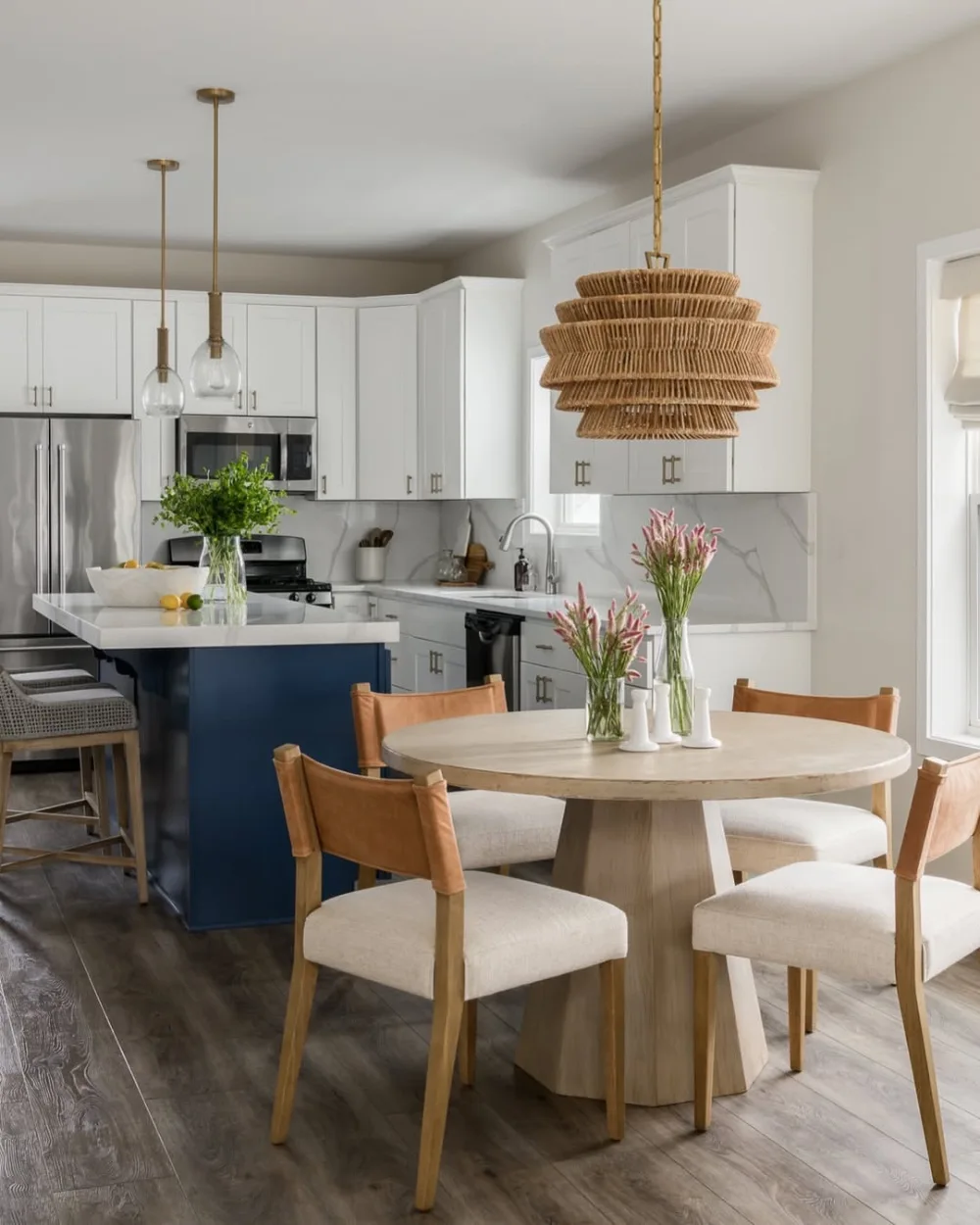 open-concept kitchen with white cabinets, blue island, and round dining table