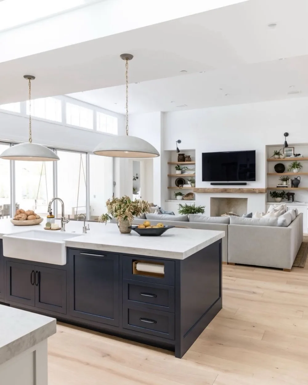 open-concept kitchen with dark island, white cabinetry, and connected living room
