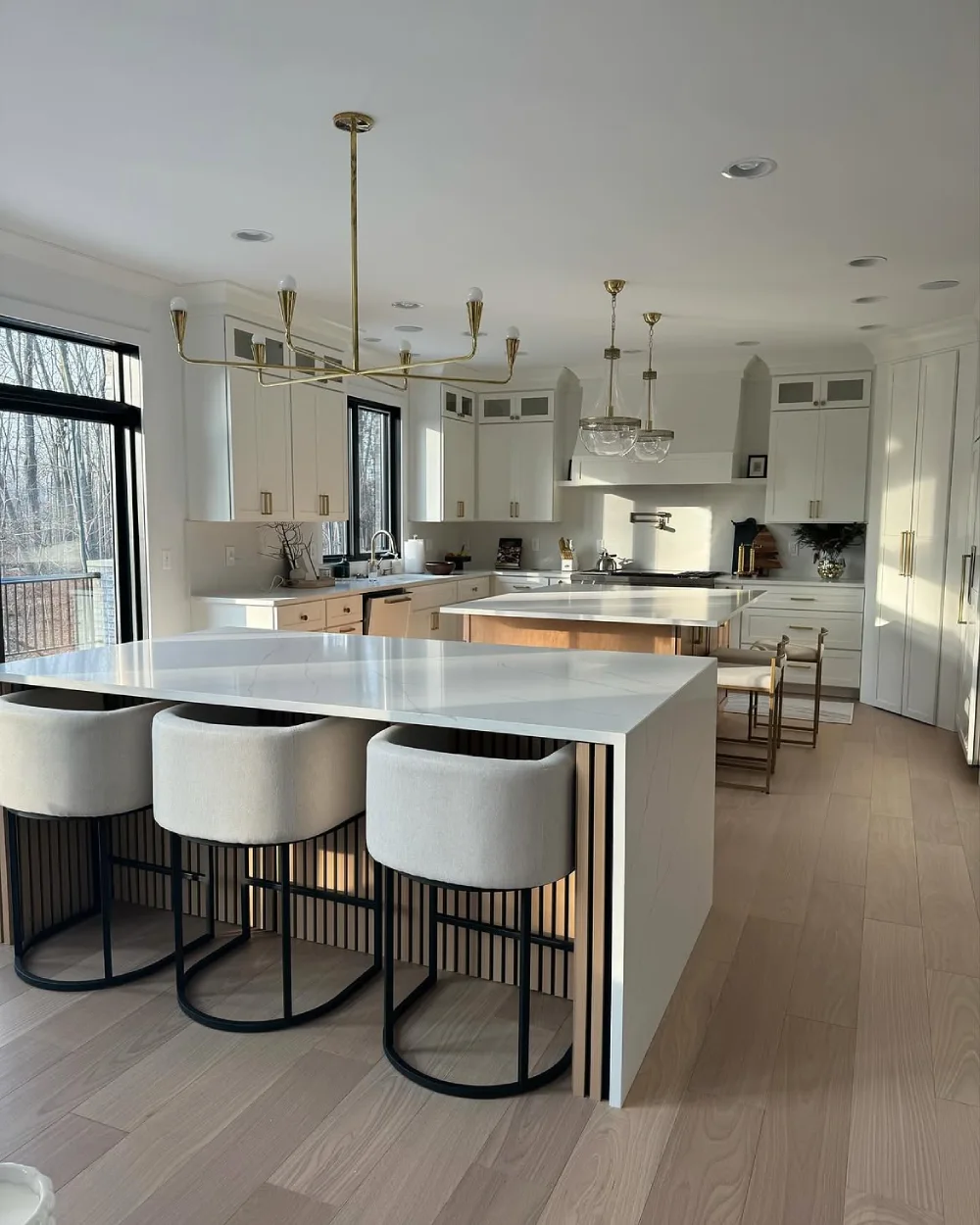 large open-concept kitchen with two islands and modern bar stools
