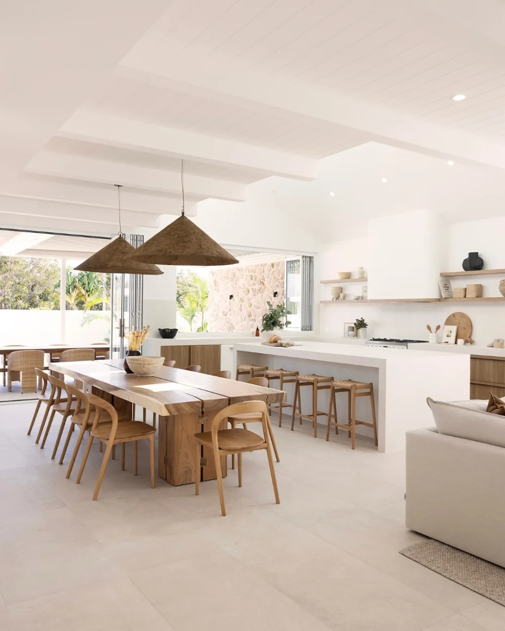 open-concept kitchen with long wooden dining table and large white island