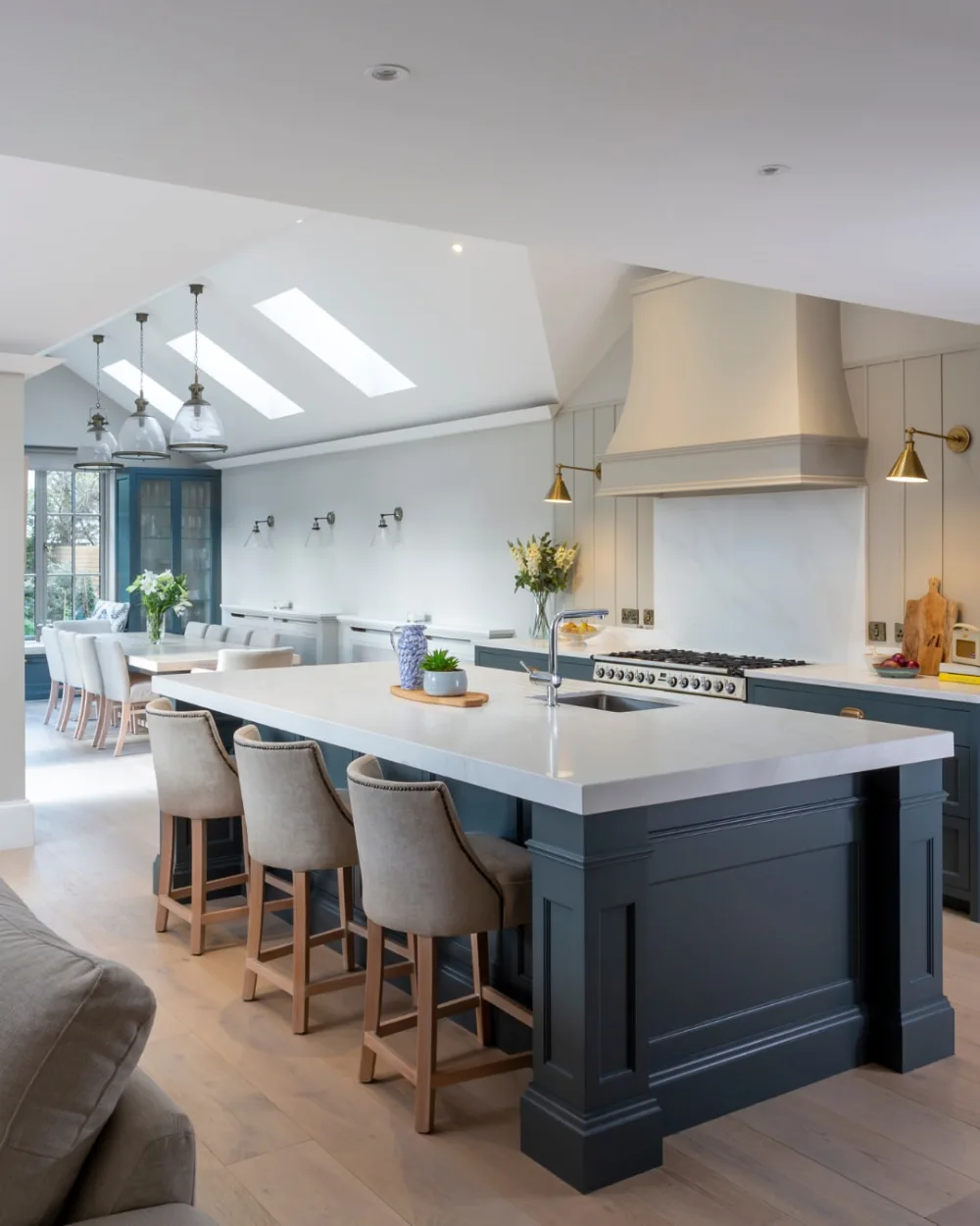 open-concept kitchen with blue island, white cabinets, and skylights