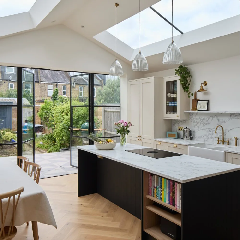open-concept kitchen with dark island, skylight, and garden-facing glass doors