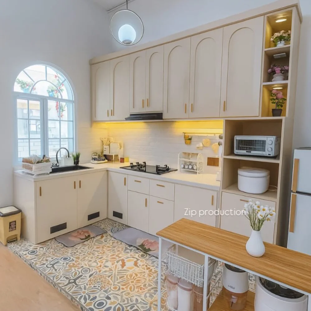 Small L-shaped kitchen with cream cabinets and a patterned tile floor