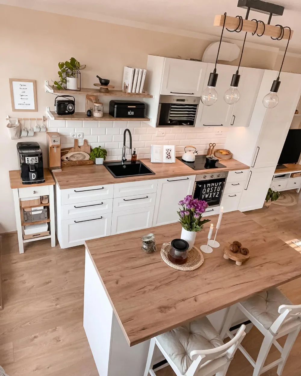 Small white kitchen with wood counters and open shelves for everyday items