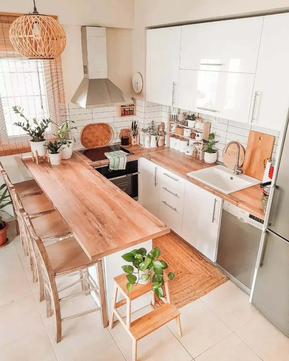 Small white kitchen with an extended wood countertop and bar stools