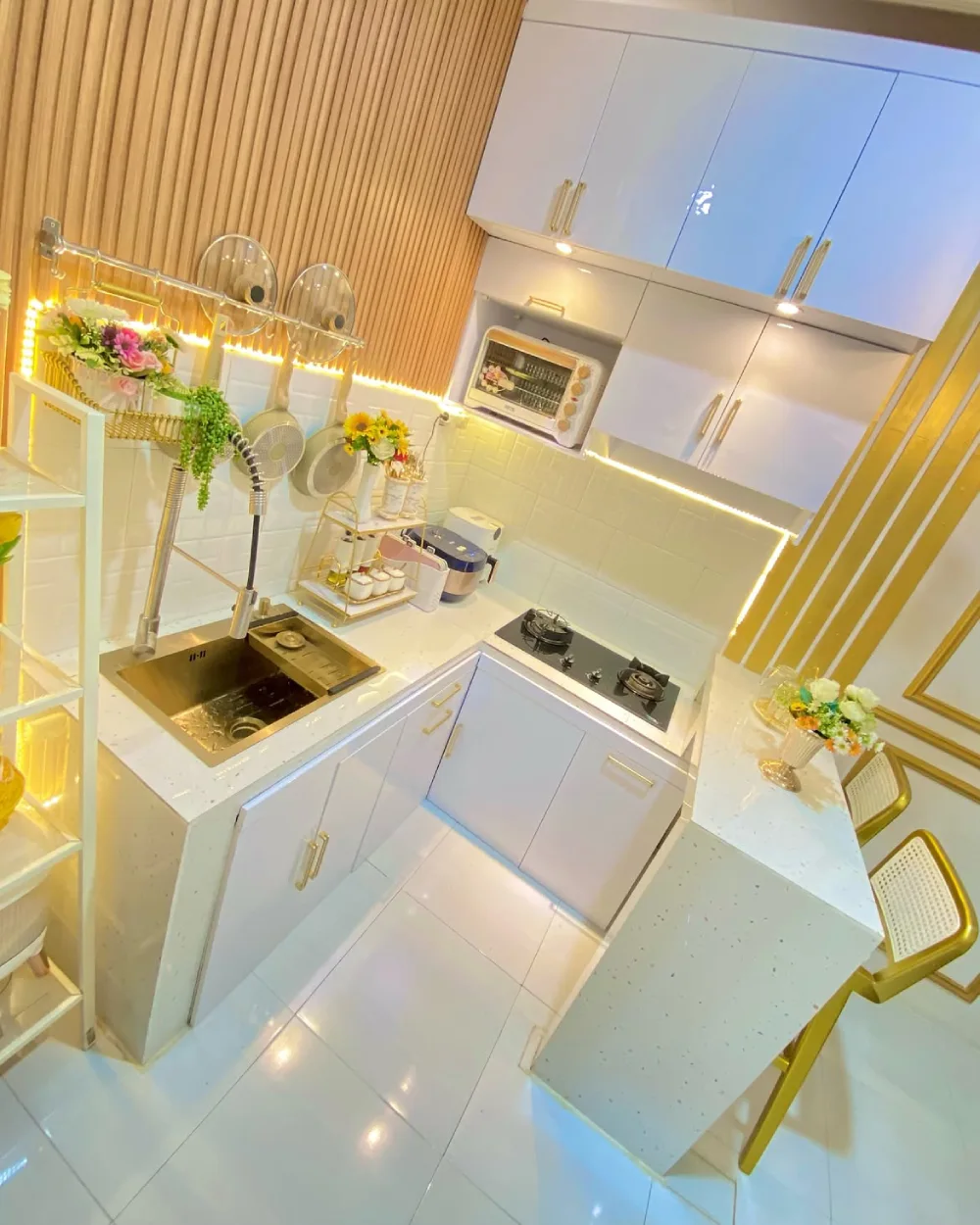 white kitchen with gold hardware, wood slat wall, and warm LED lighting