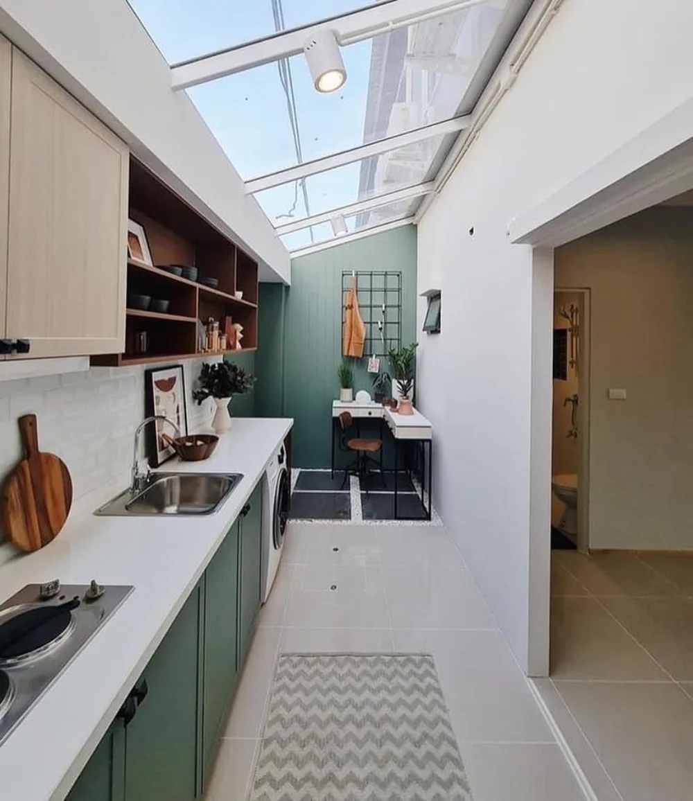 Small white kitchen with wood counters and a compact dining table by the window
