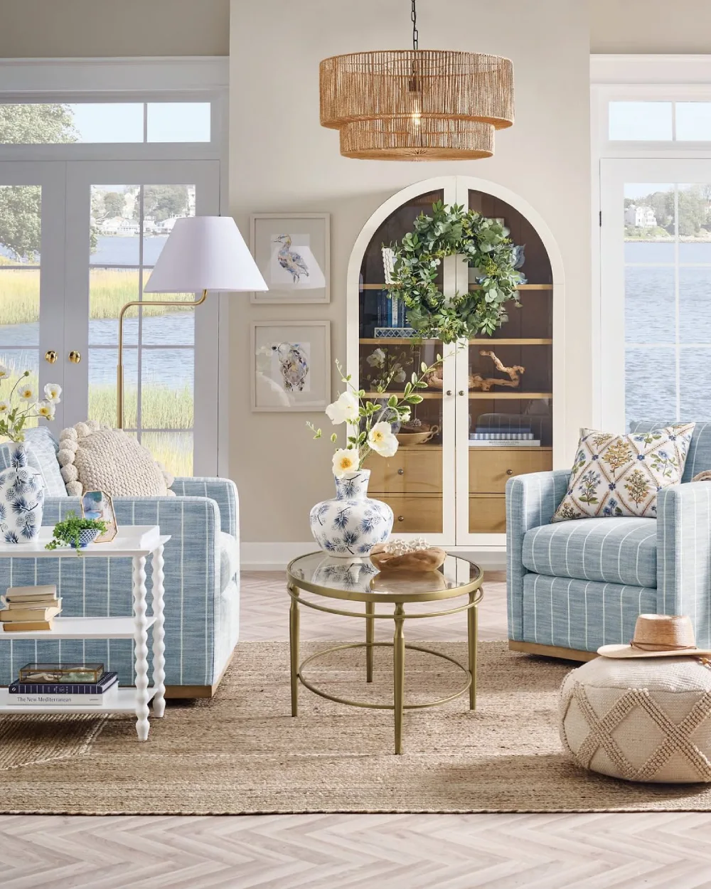Light blue coastal living room with woven chairs, striped upholstery, and natural textures