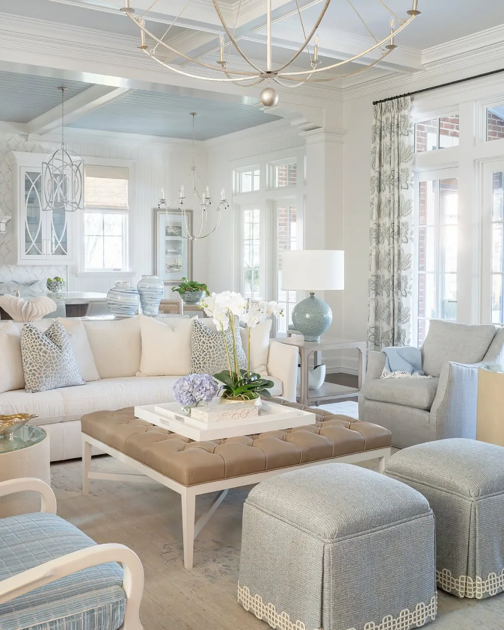 Elegant coastal living room with soft blue and white upholstery and large windows