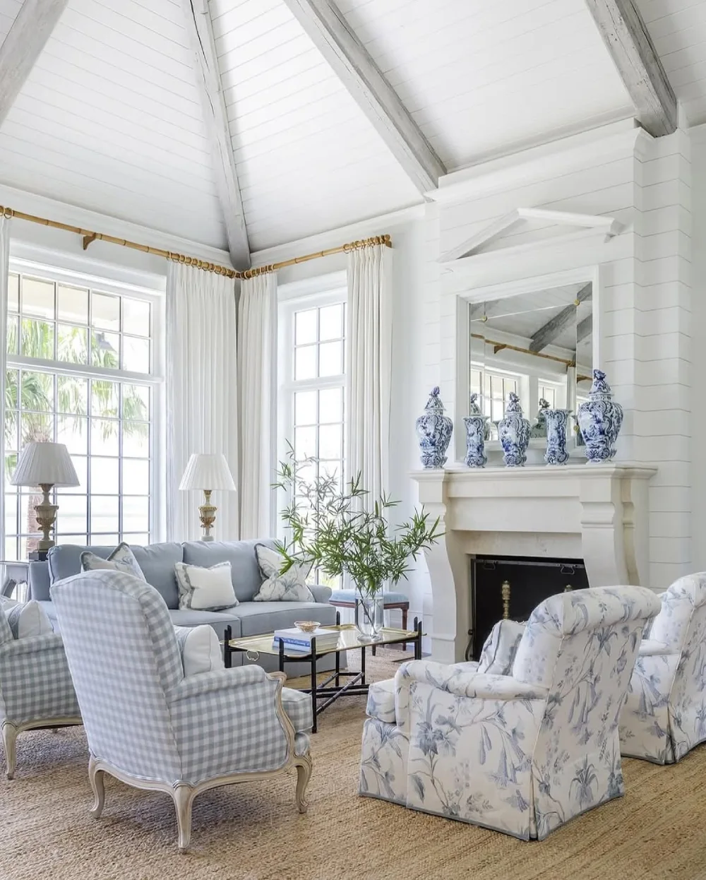Bright coastal living room with blue checked and floral armchairs around a fireplace